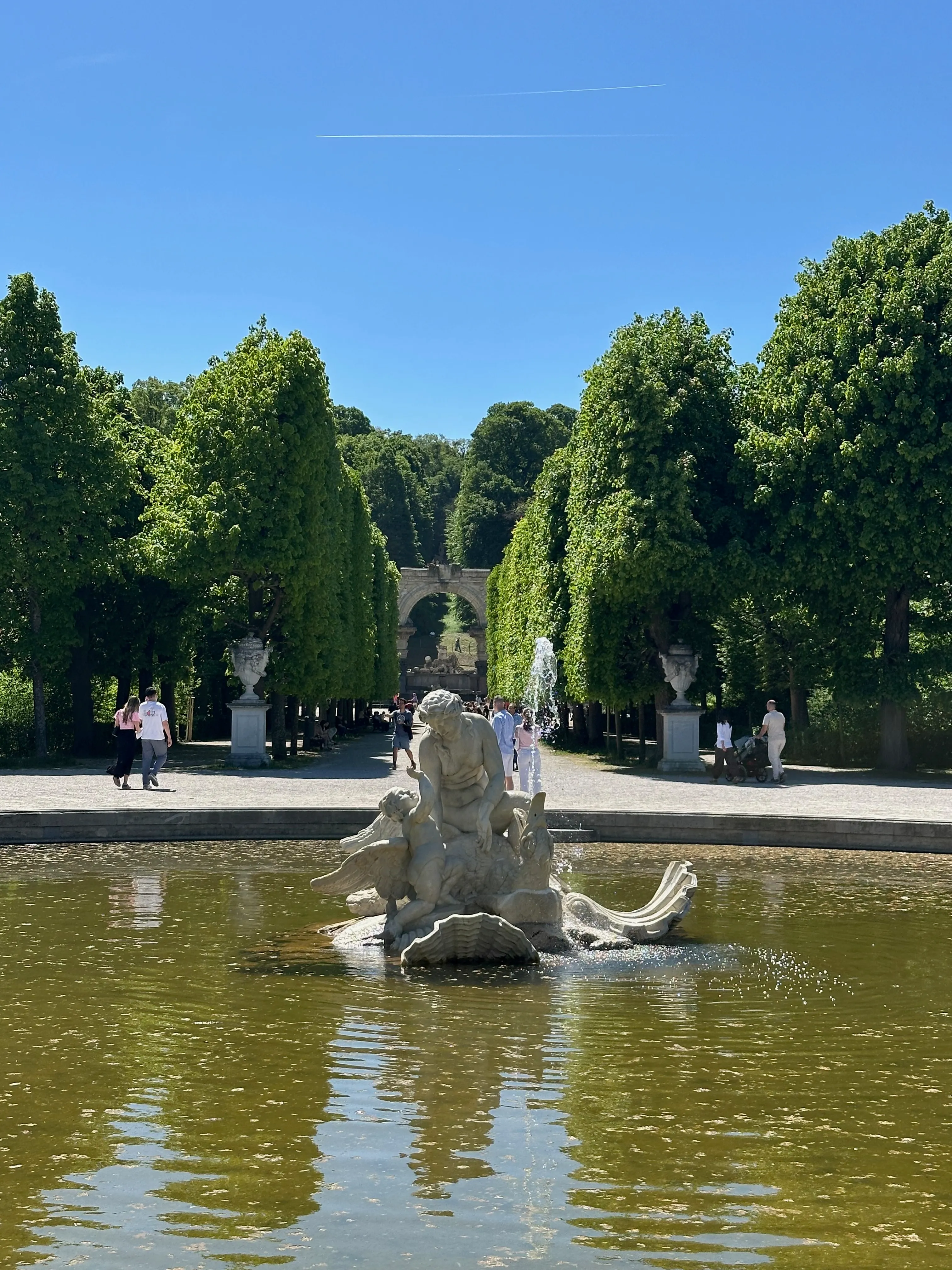 Schönbrunn's central garden axis—a fountain in the foreground with the long allée stretching up toward the Gloriette