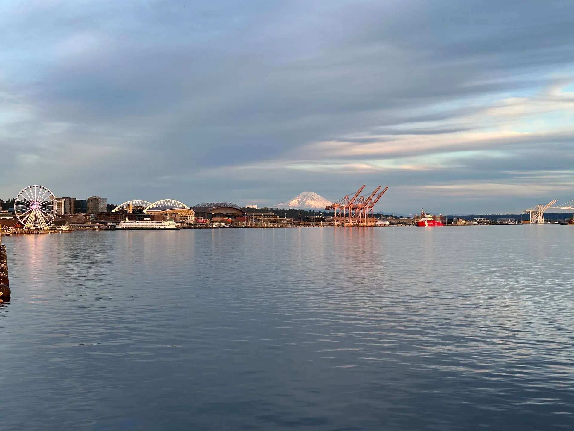 Back at the Seattle waterfront — the Great Wheel and the port at dusk, Rainier faint on the horizon