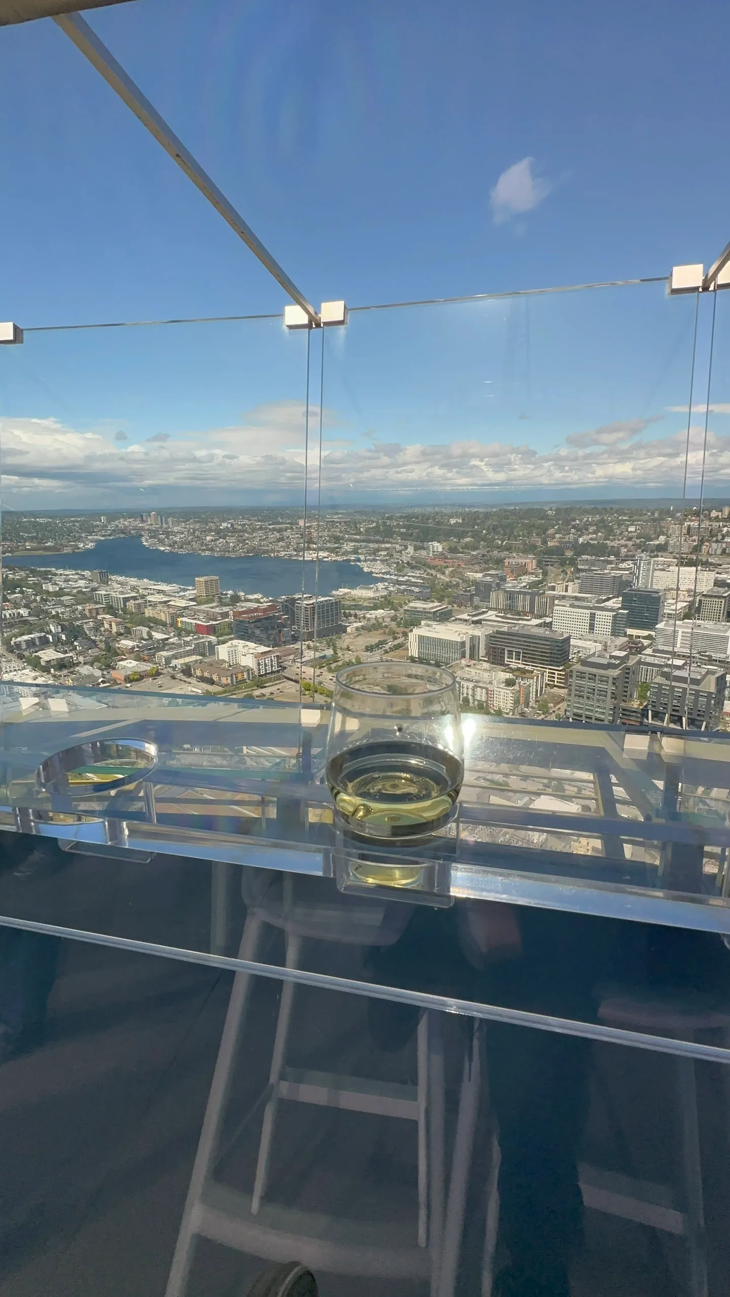 The tilted glass benches of the Space Needle's Loupe, the city below