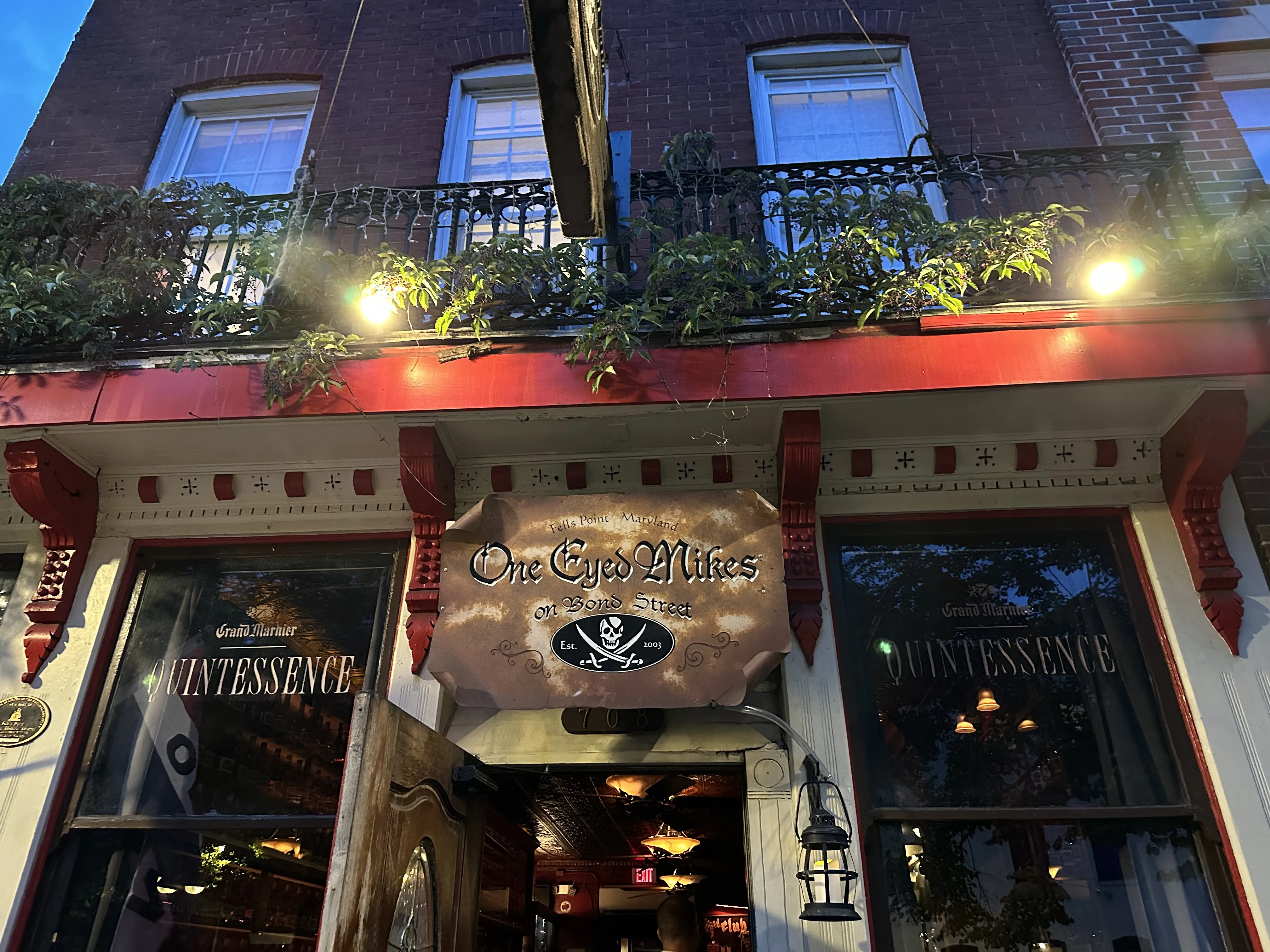 A bar exterior in Baltimore lit with red signage