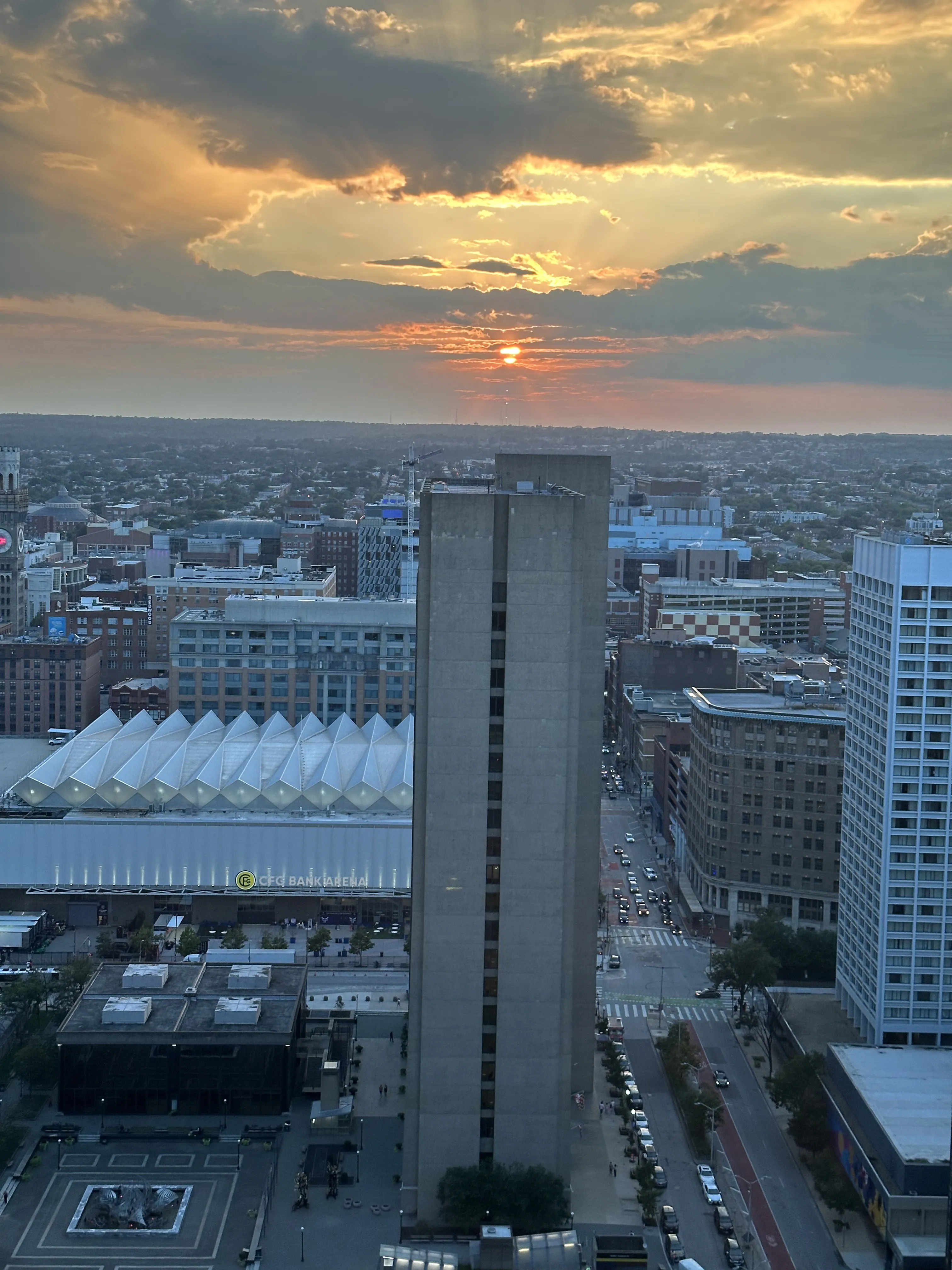Baltimore rooftops with sunset clouds gathering overhead