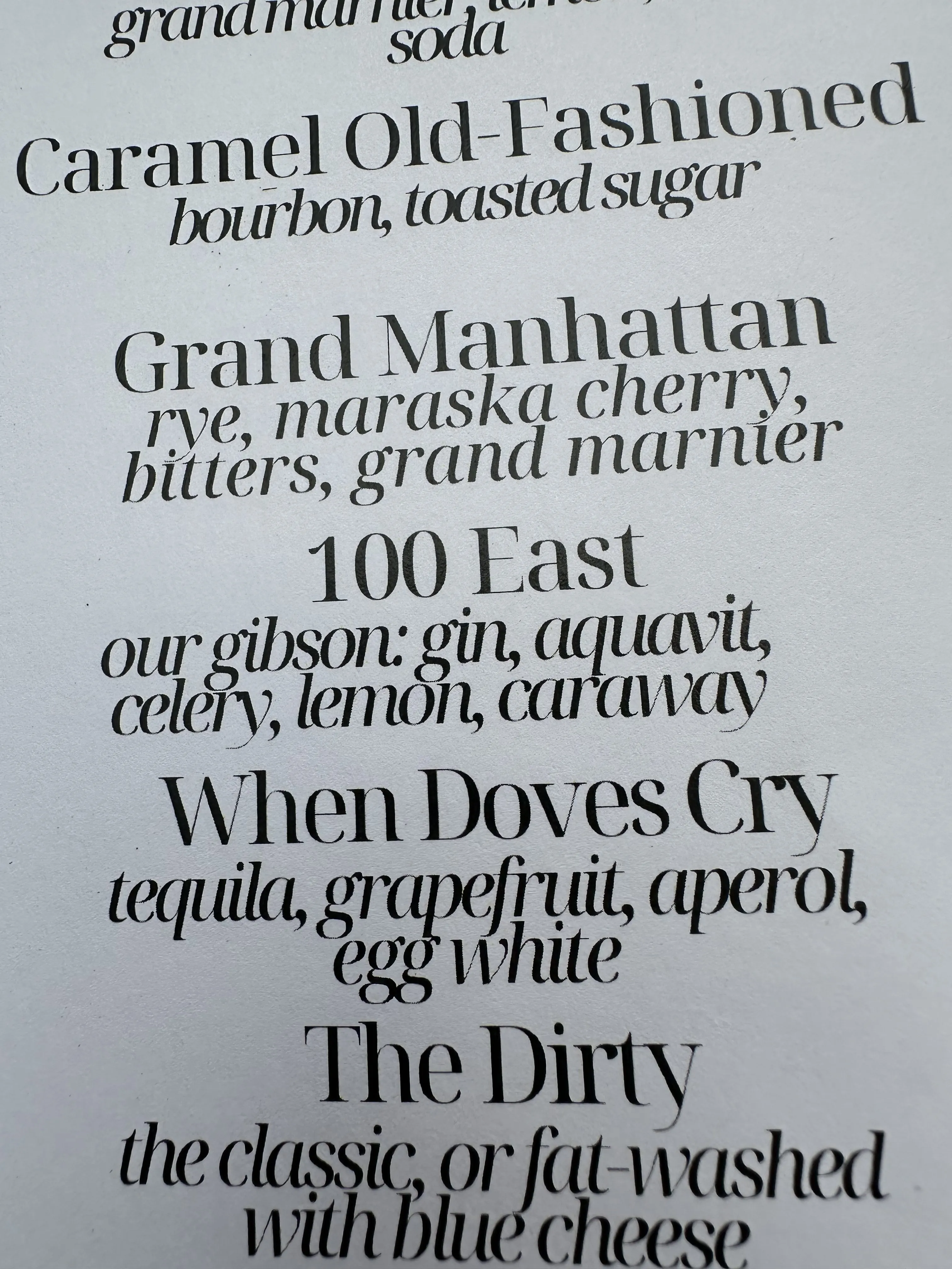 A craft cocktail menu at a Baltimore bar—Caramel Old-Fashioned, Grand Manhattan, 100 East, When Doves Cry, The Dirty