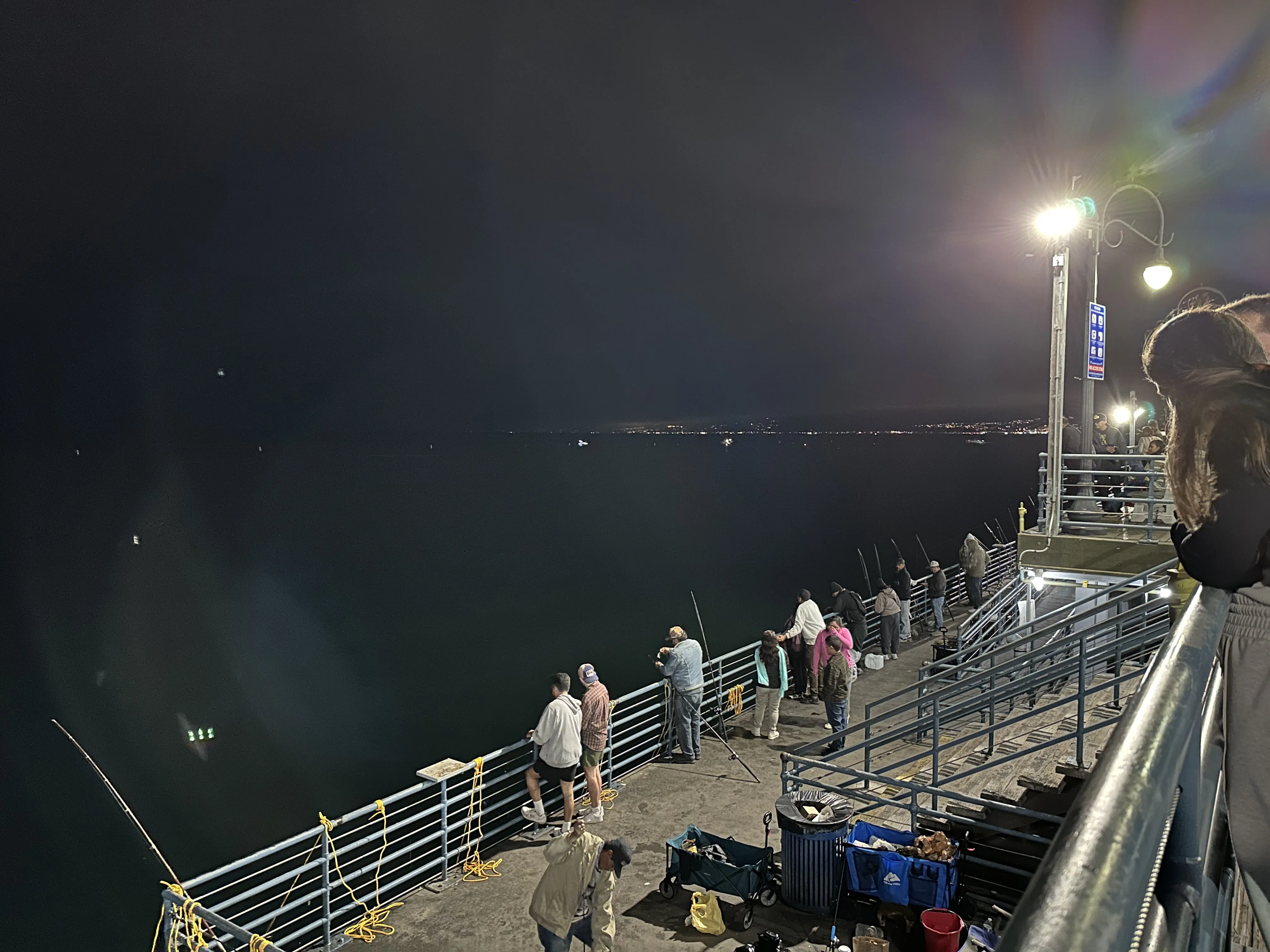 Santa Monica Pier at night with people walking the boardwalk