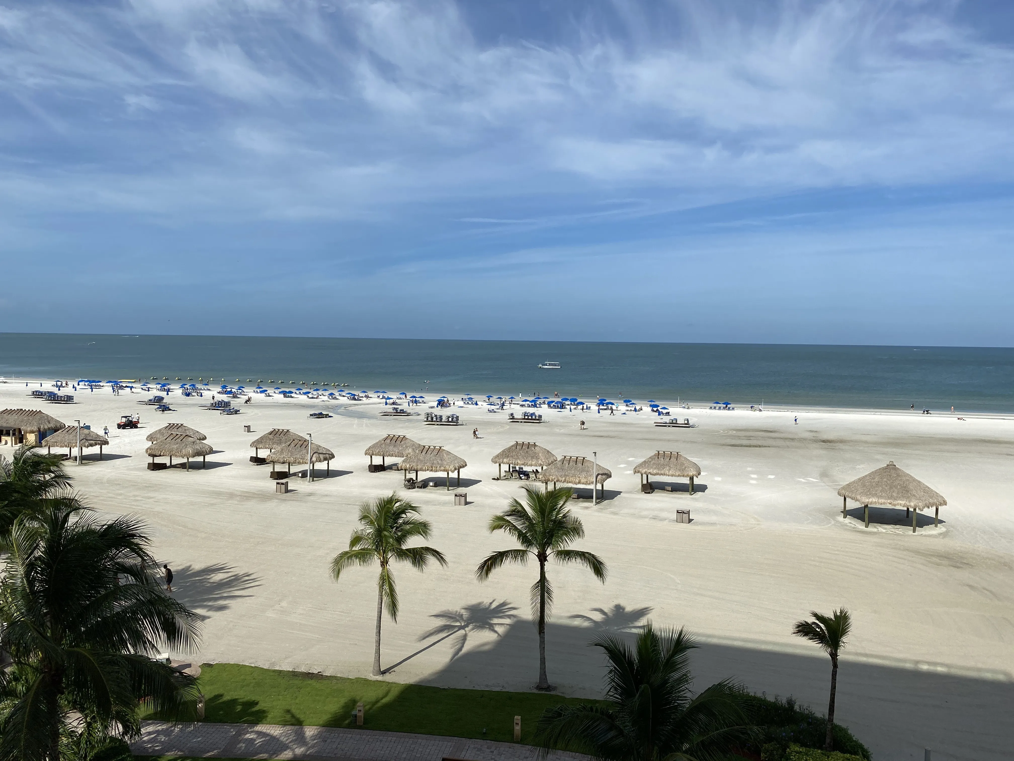 Beach umbrellas lined up in rows on the white sand