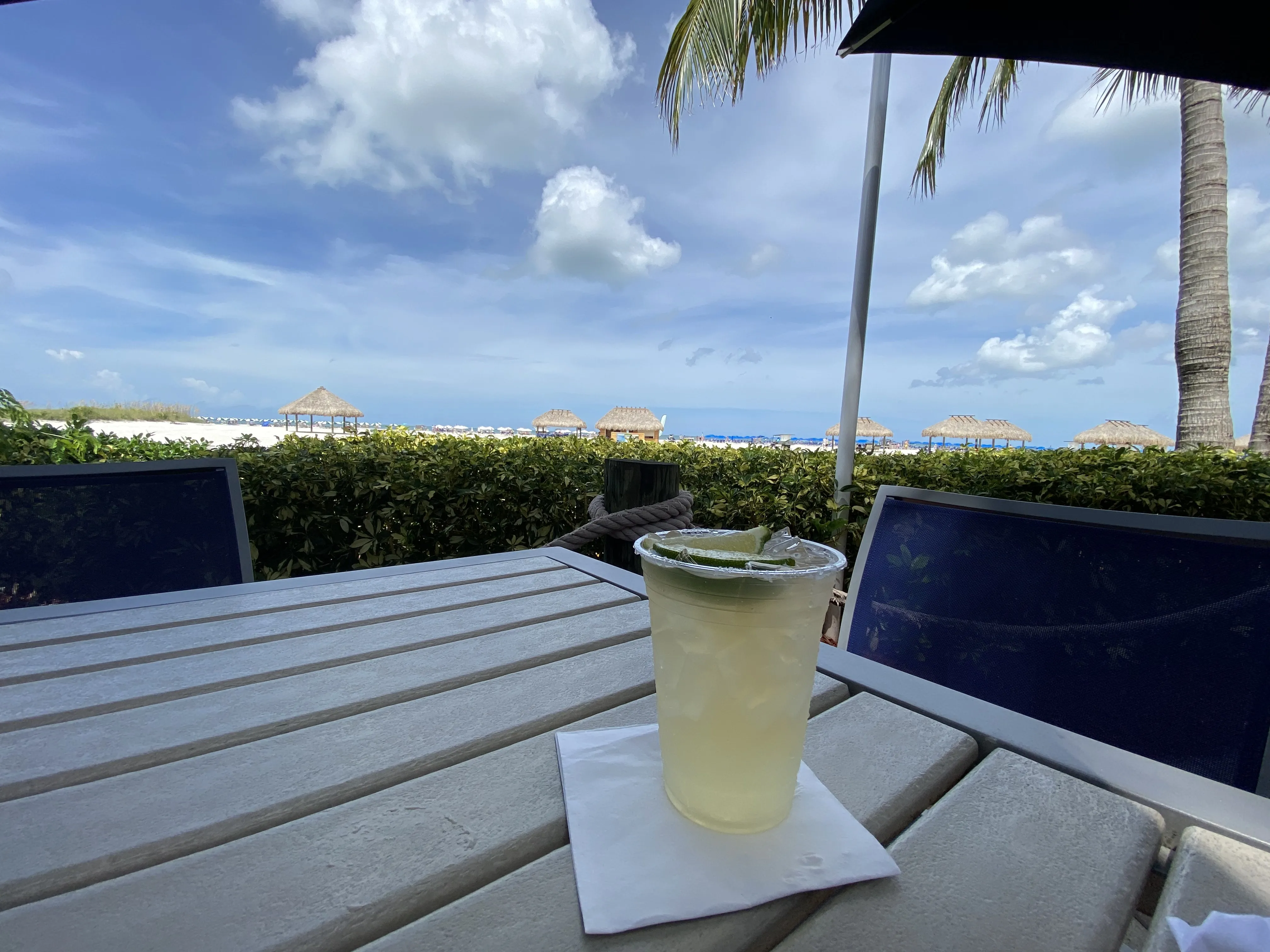 A margarita on the beach-bar table, thatched cabanas and the Gulf beyond