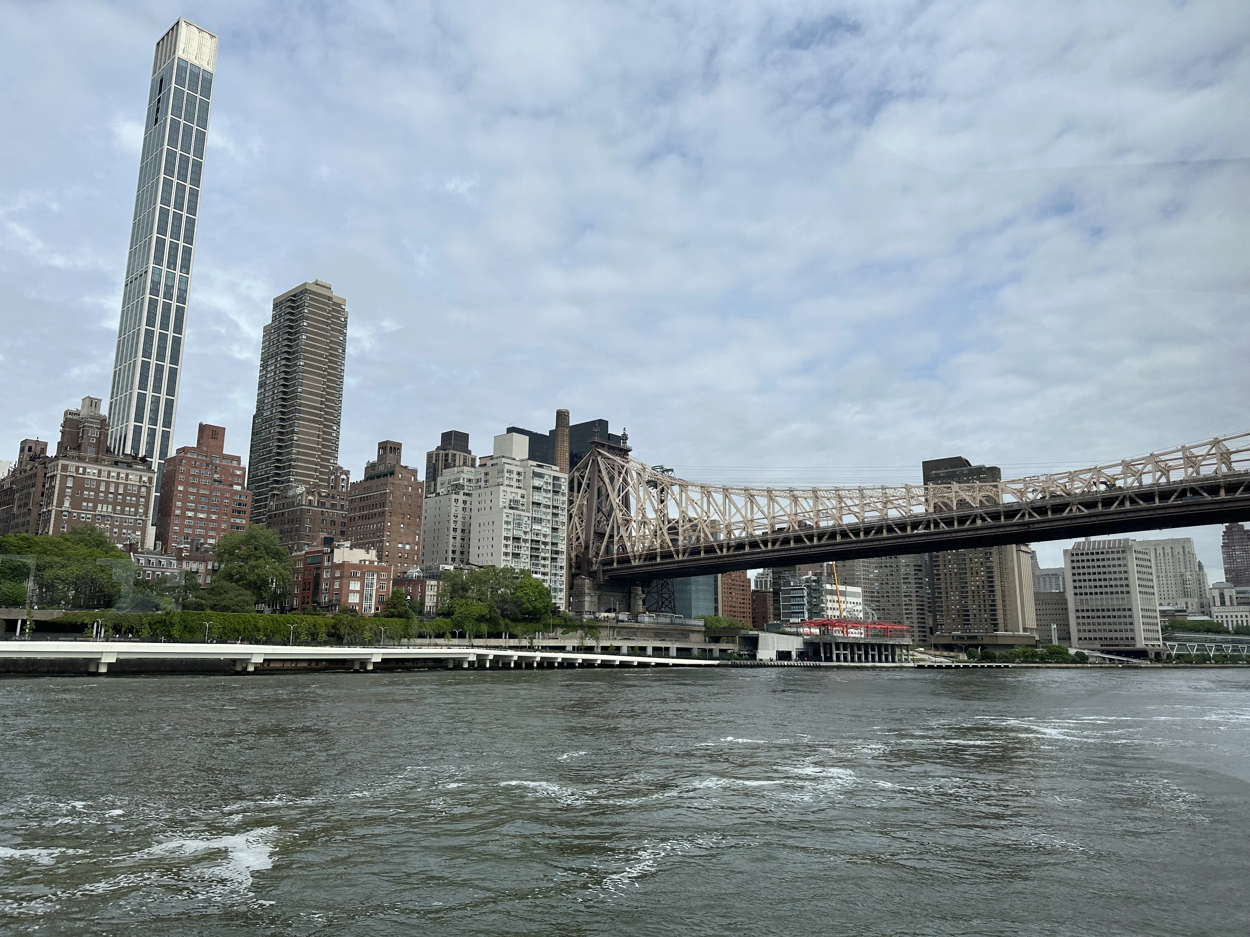 Manhattan skyline beyond a steel bridge truss
