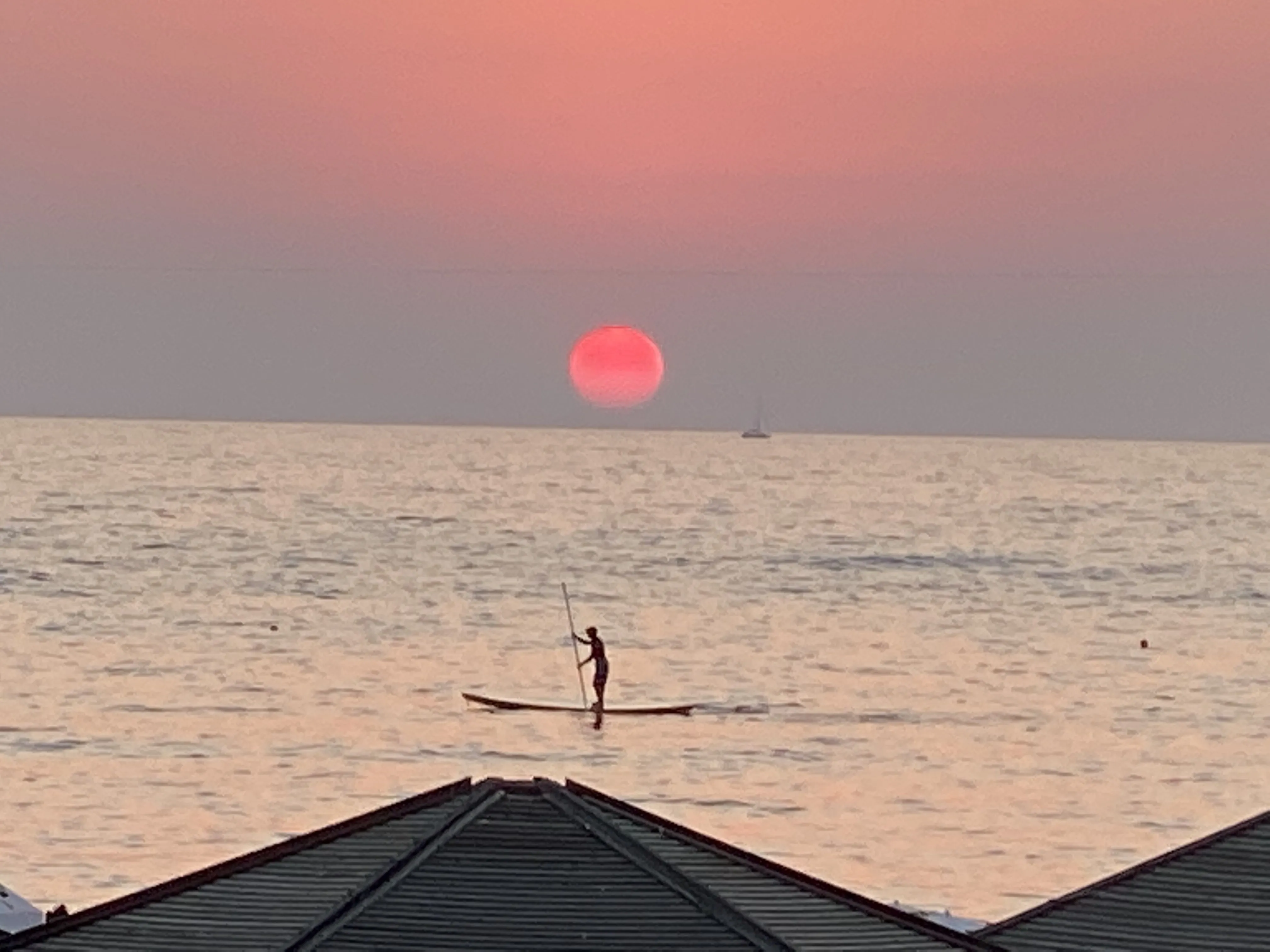 Paddleboarder silhouetted against the Mediterranean sunset