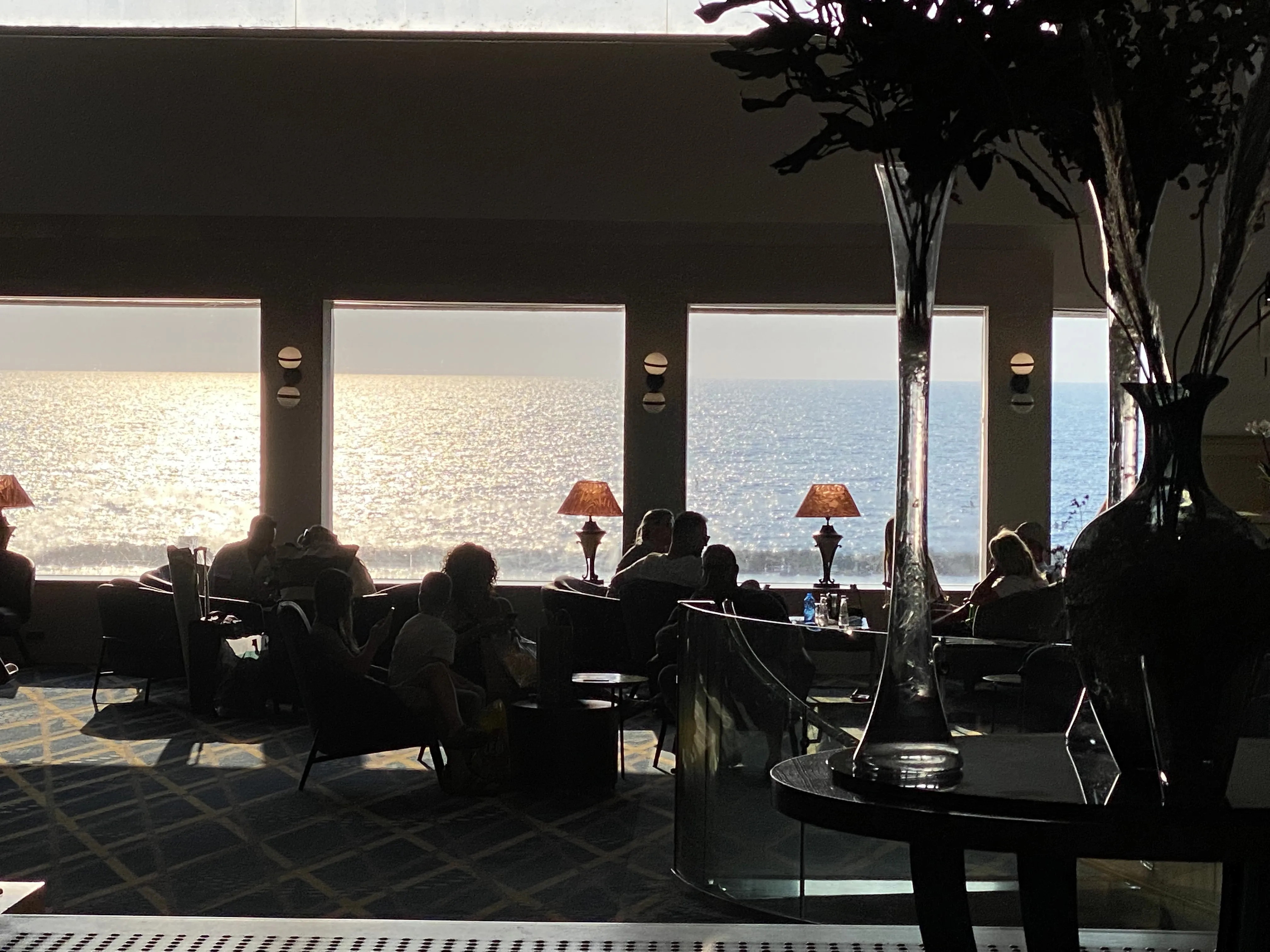 Restaurant interior at night with the Mediterranean visible through the windows
